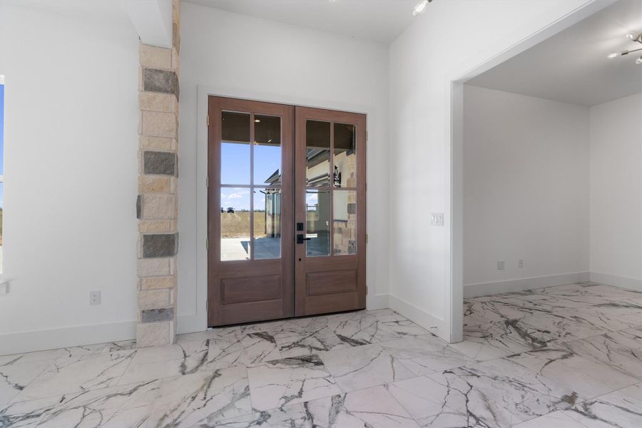 Enter through glass-paned double doors onto polished marble-look tile flooring. Enter through glass-paned double doors onto polished marble-look tile flooring.