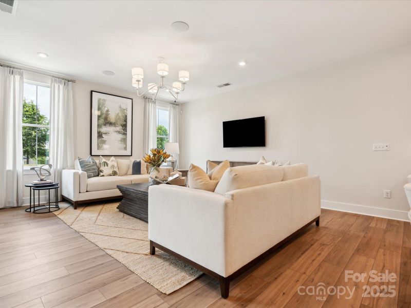 Large great room bathed in light from large windows. *Model Photos | Actual finishes, structural selections, and orientation may vary.