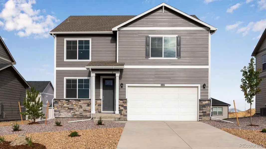 Front exterior of a new home in Sky Ranch, Watkins, CO, highlighting curb appeal (Image 1).