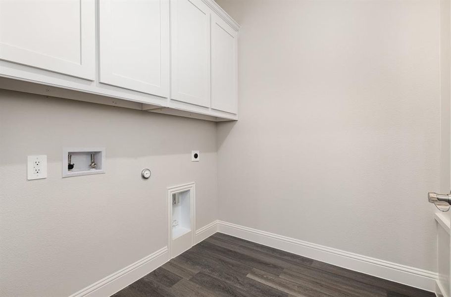 Washroom featuring gas dryer hookup, dark wood-style floors, hookup for an electric dryer, washer hookup, and cabinet space Washroom featuring gas dryer hookup, dark wood-style floors, hookup for an electric dryer, washer hookup, and cabinet space