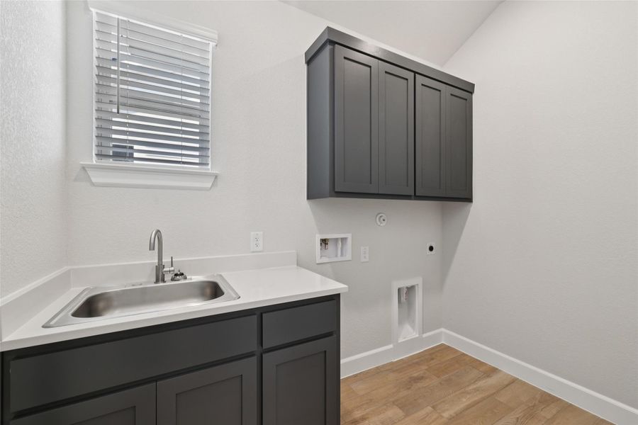 Laundry room with cabinet space, hookup for an electric dryer, washer hookup, light wood-type flooring, and gas dryer hookup