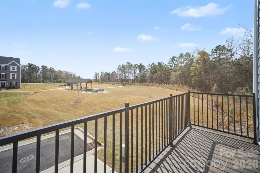 Private balcony overlooking green space and community wooded gathering area