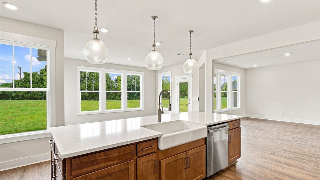 Highly skilled craftsmanship shines in this modern kitchen with pendant lighting and a central island focal point