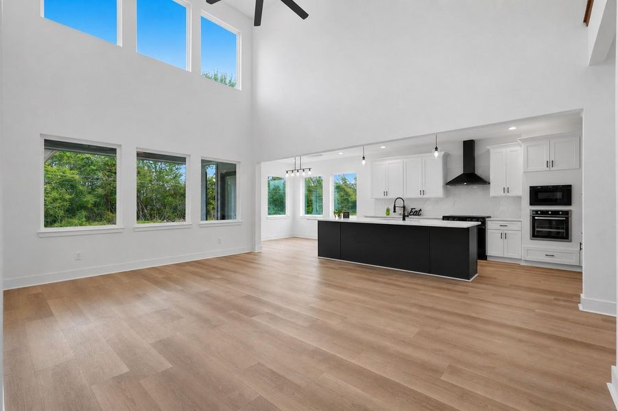 This spacious, open-plan kitchen and living area features high ceilings, abundant natural light from large windows, and modern finishes. This spacious, open-plan kitchen and living area features high ceilings, abundant natural light from large windows, and modern finishes.