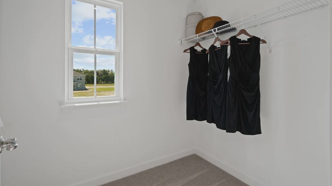 Primary suite walk-in closet with window in a DRB Home Clementine model at the Trinity Place community.