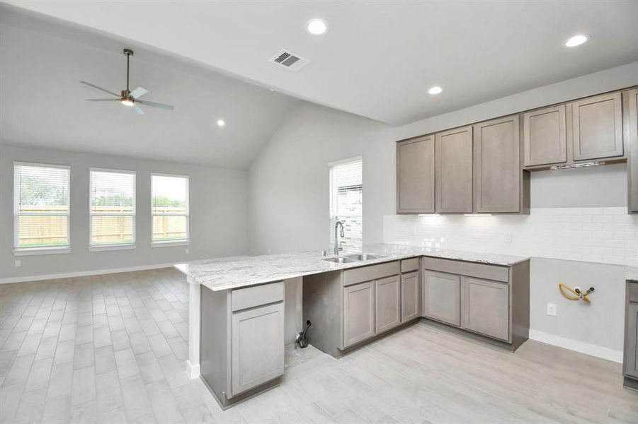 The open concept effortlessly connects the kitchen to the expansive family room, forming a perfect hub for gatherings. This seamless flow creates an inviting space where cooking and socializing come together harmoniously. Example photo of completed home with similar plan. Actual may vary.