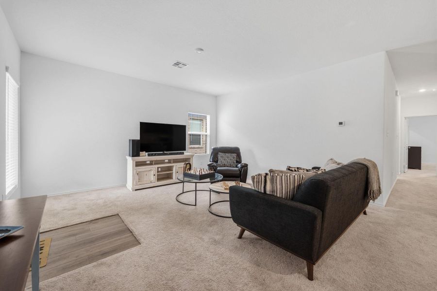 Expansive living area with neutral carpeting and light-toned walls