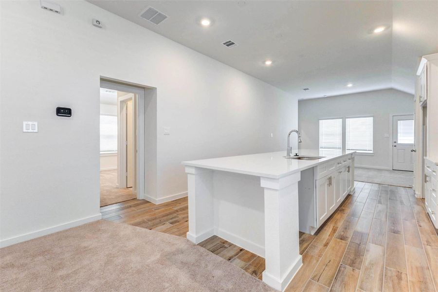 Another view of the living area highlights the impressive ceiling height, bright white walls, and open sightlines back toward the entry. The neutral carpet and clean finishes create a blank canvas, while the nearby openings provide convenient access to additional spaces throughout the home. Another view of the living area highlights the impressive ceiling height, bright white walls, and open sightlines back toward the entry. The neutral carpet and clean finishes create a blank canvas, while the nearby openings provide convenient access to additional spaces throughout the home.