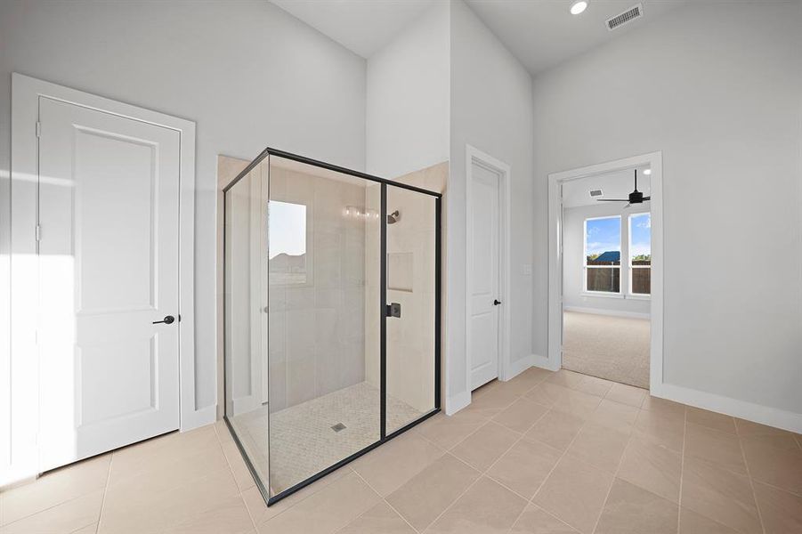 Full bathroom with light tile patterned floors, a shower stall, and ceiling fan Full bathroom with light tile patterned floors, a shower stall, and ceiling fan