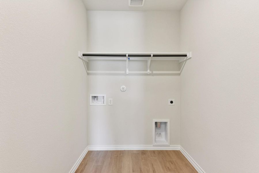 Laundry room featuring light wood-style flooring, hookup for a gas dryer, electric dryer hookup, and hookup for a washing machine