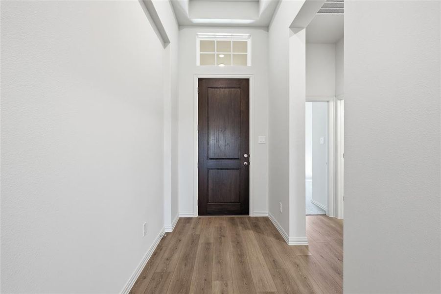 Foyer entrance featuring light wood-type flooring and a high ceiling