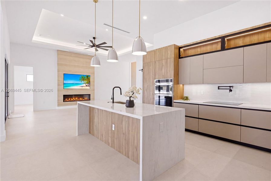 Oversized waterfall island with quartz countertops provides generous prep space and casual seating. Oversized waterfall island with quartz countertops provides generous prep space and casual seating.