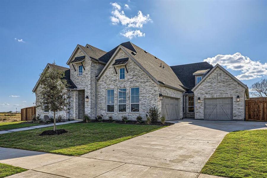 French country style house featuring a front yard and a garage