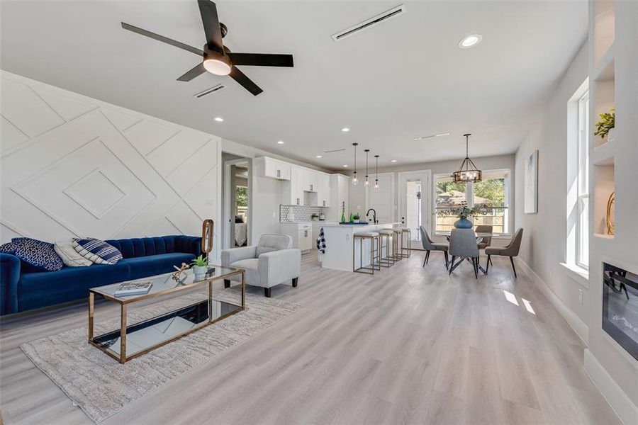 Living room featuring sink, ceiling fan, and light hardwood / wood-style flooring