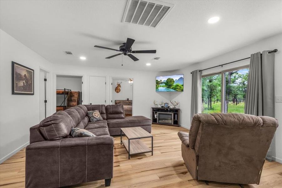 Spacious room featuring wood-finish flooring, recessed lighting, and a modern ceiling fan
