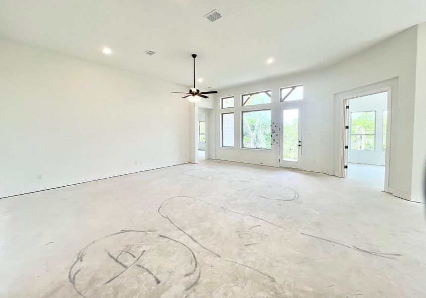 Unfurnished living room with ceiling fan, recessed lighting, and concrete flooring Unfurnished living room with ceiling fan, recessed lighting, and concrete flooring