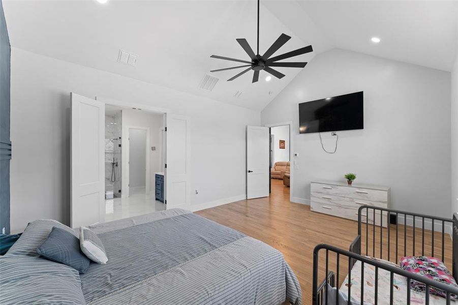 Bedroom featuring light wood-type flooring, a ceiling fan, and high vaulted ceiling Bedroom featuring light wood-type flooring, a ceiling fan, and high vaulted ceiling