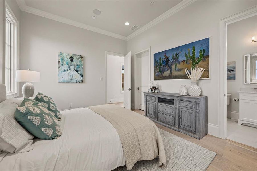 Bedroom featuring crown molding, light wood finished floors, recessed lighting, connected bathroom, and multiple windows Bedroom featuring crown molding, light wood finished floors, recessed lighting, connected bathroom, and multiple windows