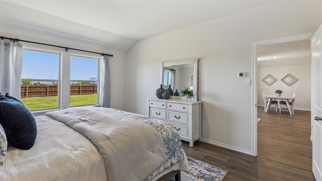 Bedroom with dark wood-type flooring and vaulted ceiling