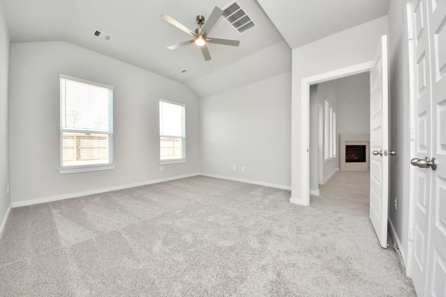 Come and unwind after a long day in this magnificent primary suite! This spacious room features plush carpet, warm paint, high ceilings and large windows with privacy blinds. Sample photo of completed home with similar floor plan. Actual colors and selections may vary.