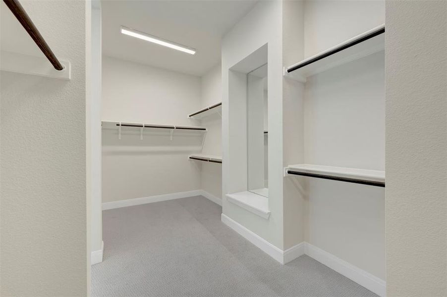 Walk in closet featuring light colored carpet