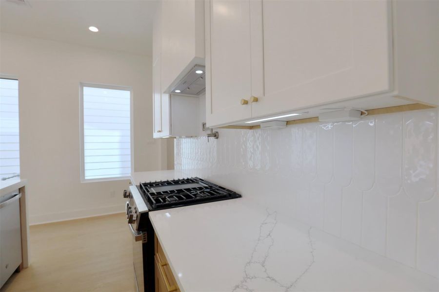 Uninterrupted backsplash is illuminated by the under cabinetry lights, paired with outlets for an increase of kitchen cooking ease. Uninterrupted backsplash is illuminated by the under cabinetry lights, paired with outlets for an increase of kitchen cooking ease.