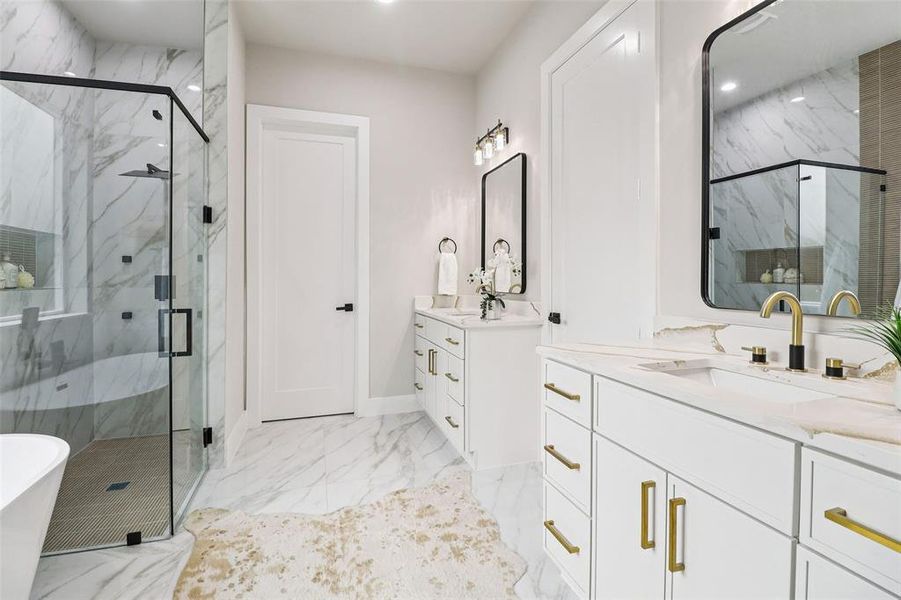 Bathroom featuring a soaking tub, a marble finish shower, light marble finish floors, two vanities, and recessed lighting