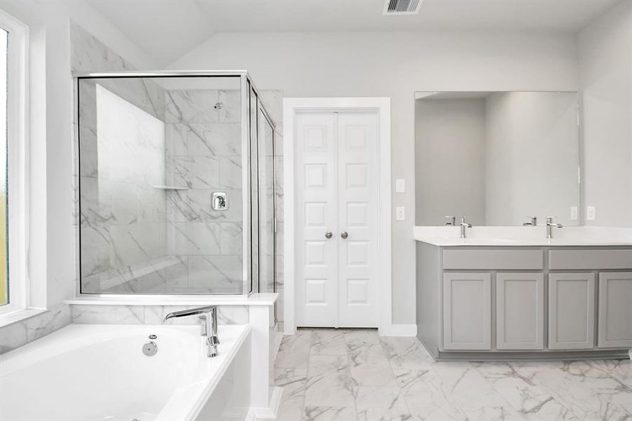 Experience luxury in this spa-like primary bathroom featuring a massive walk-in shower with tile surround. Sample photo of similar plan. Actual colors and selections may vary.