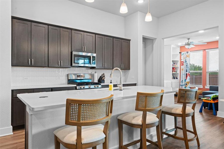 The chef's kitchen features stainless steel appliances, and a large island with enough space for bar stools!