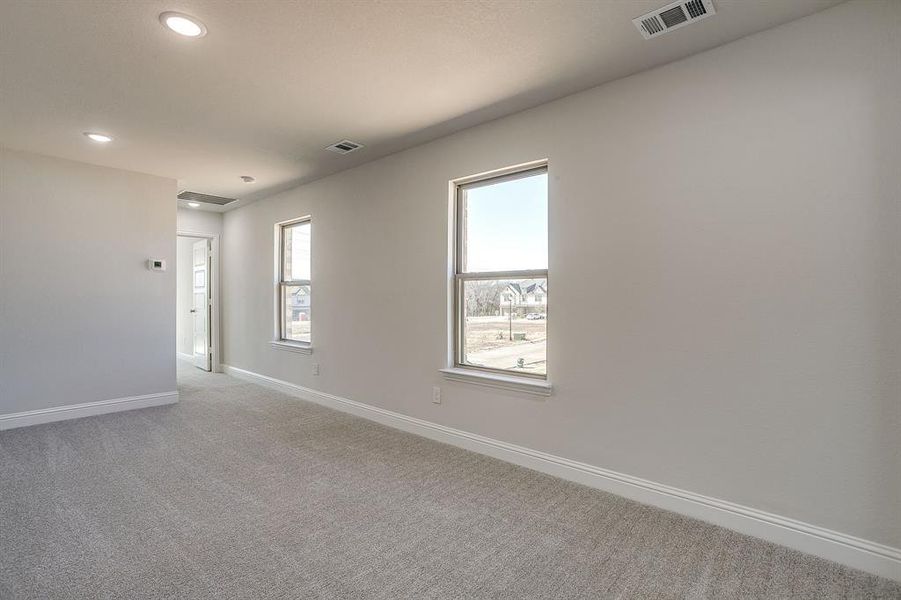 Carpeted empty room with baseboards and recessed lighting