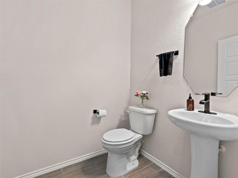 Half bath with wood tiled floors and a textured wall