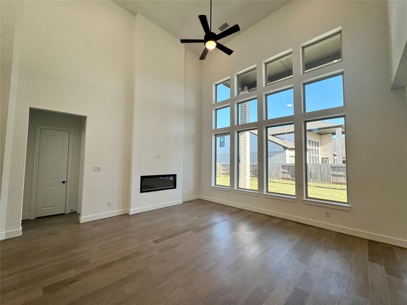 Two Story Family Room beautiful hardwood floors, wall of window with electric fireplace