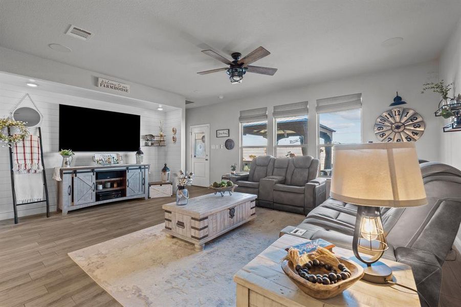 Living room featuring ceiling fan and light hardwood / wood-style flooring