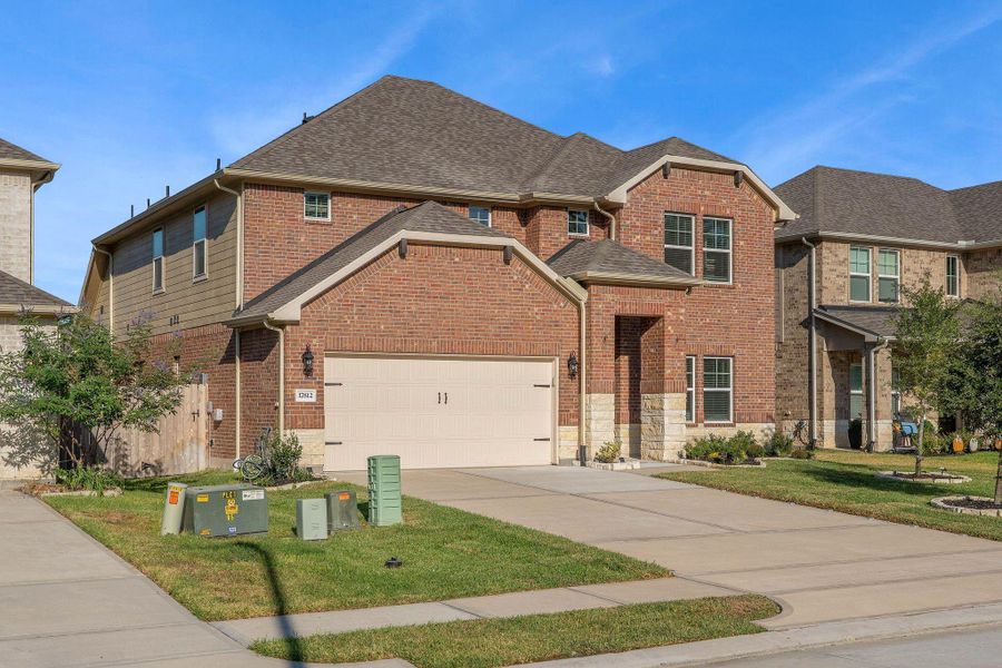 This is a modern two-story brick home with a two-car garage, well-maintained lawn, and a tidy front entrance. It's located in a suburban neighborhood with similar style homes. This is a modern two-story brick home with a two-car garage, well-maintained lawn, and a tidy front entrance. It's located in a suburban neighborhood with similar style homes.