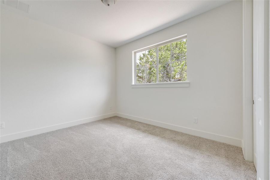 Spare room with light colored carpet and baseboards