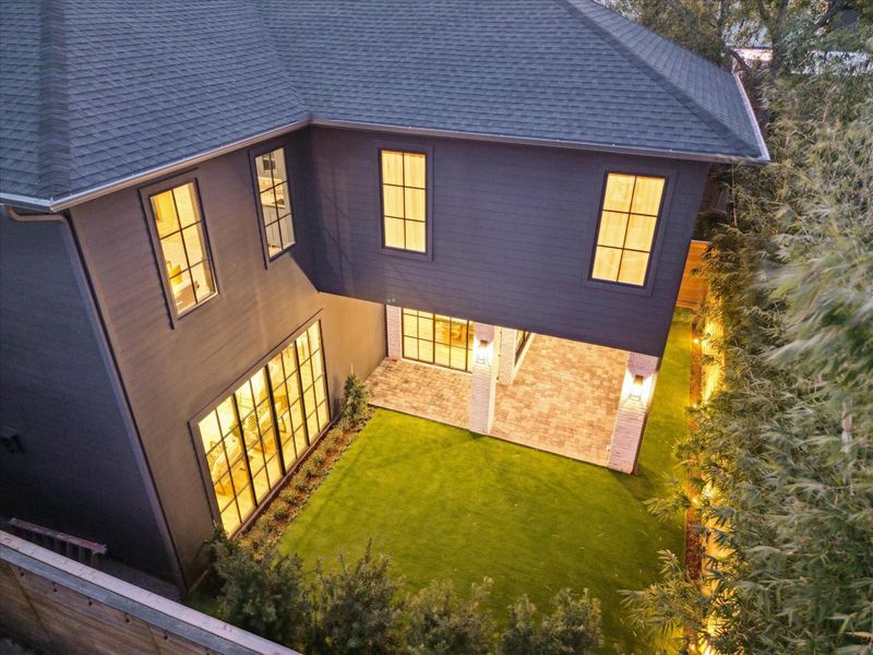 An aerial view of the rear of the home shows the great space, surrounding landscaping, and low-maintenance artificial turf.  A great space for Inner-Loop living!