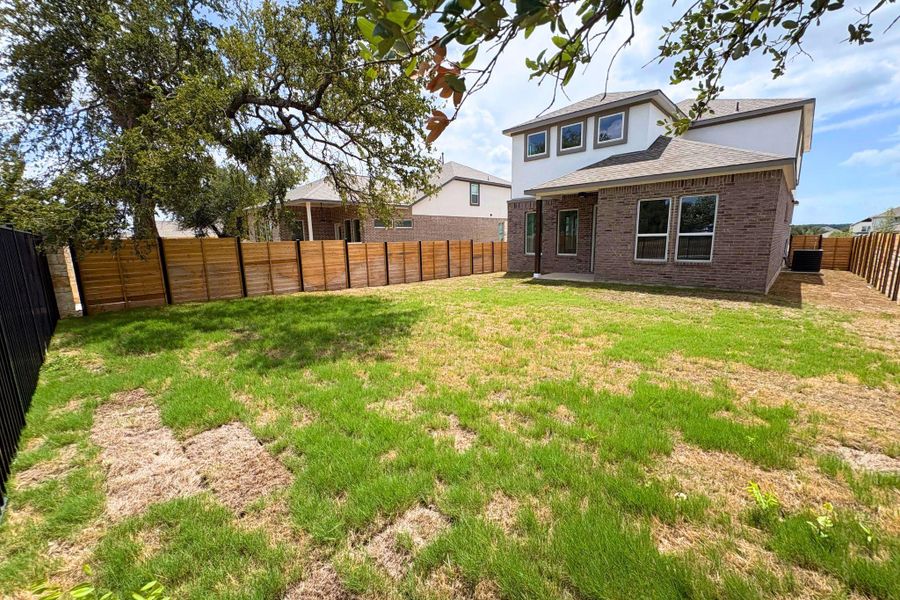 An enclosed grassy backyard extends from the brick and siding exterior of this home. An enclosed grassy backyard extends from the brick and siding exterior of this home.