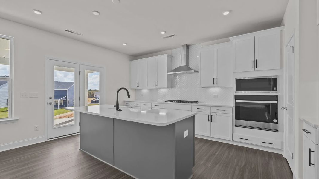 Burton Design gourmet kitchen with wall oven & microwave, vented hood, & cooktop. At Lakeside Glen by DRB Homes in York, SC. Burton Design gourmet kitchen with wall oven & microwave, vented hood, & cooktop. At Lakeside Glen by DRB Homes in York, SC.