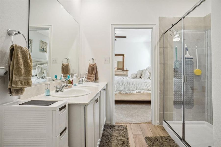 Bathroom with wood-type flooring, vanity, and walk in shower