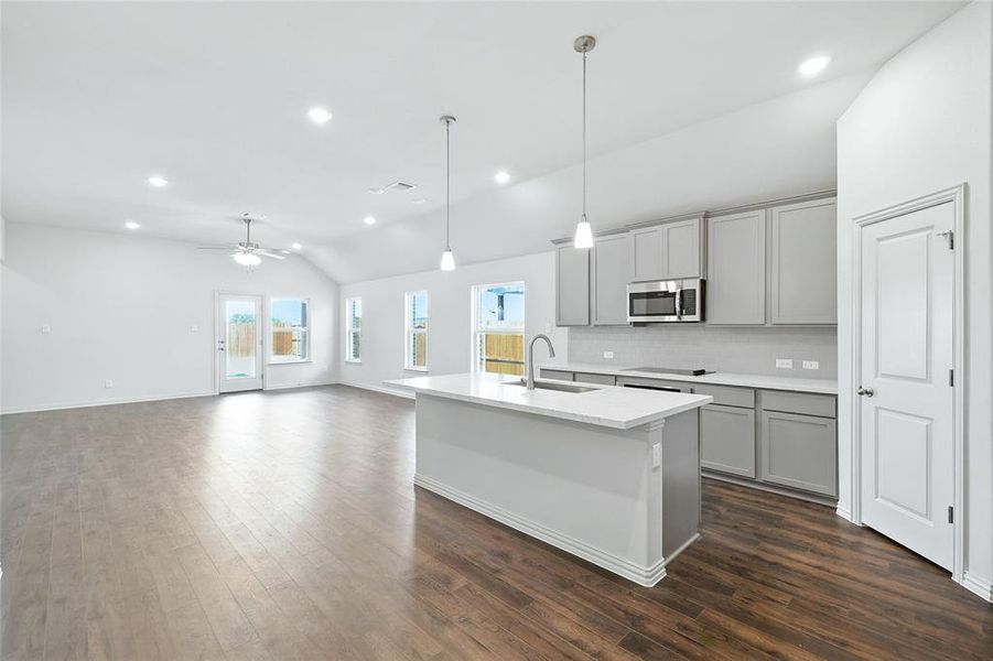Kitchen featuring gray cabinetry, vaulted ceiling, decorative light fixtures, tasteful backsplash, and recessed lighting Kitchen featuring gray cabinetry, vaulted ceiling, decorative light fixtures, tasteful backsplash, and recessed lighting