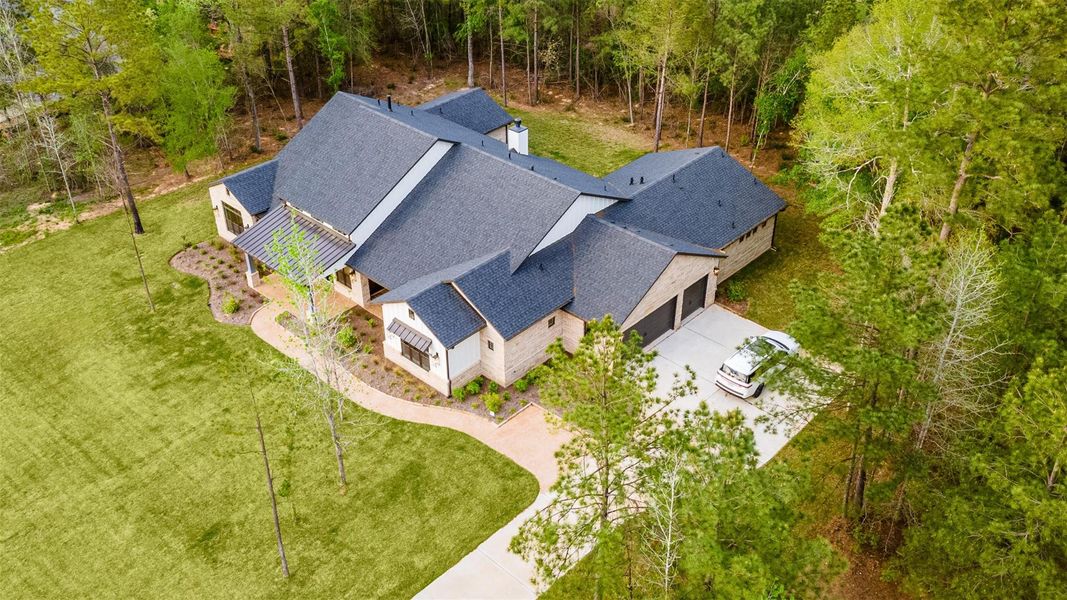 This aerial shows the multiple roof lines and how the property sits on this spacious 1.5 acre lot surrounded by trees on three sides offering wonderful shade and offering privacy to relax and enjoy the peace and tranquility of High Meadow Estates living.  This beautiful community provides great amenities to include a resort type pool for its residents, tennis courts and walking trails.  Close enough to the Woodlands for the convenience of great retail and restaurants and yet just far enough to truly relax!
