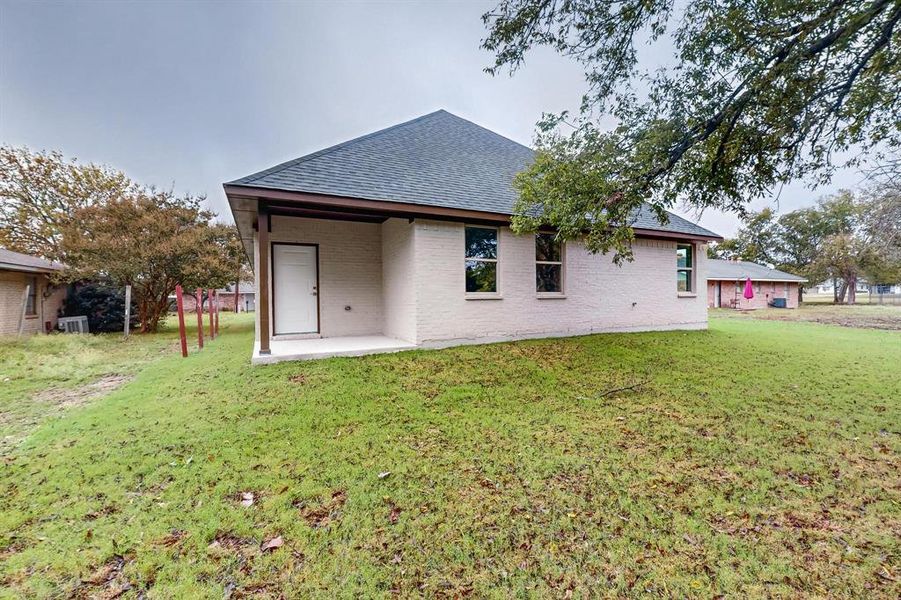 Rear view of house featuring a lawn