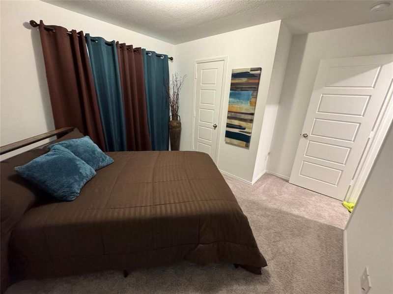 Carpeted bedroom with a textured ceiling