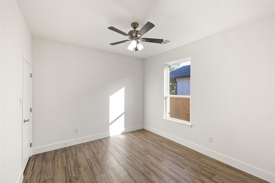 Spare room with hardwood / wood-style floors and ceiling fan