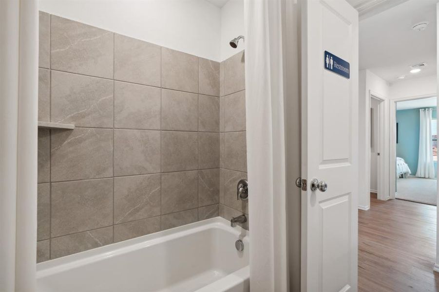 Bathroom featuring hardwood / wood-style floors and shower / bath combo with shower curtain