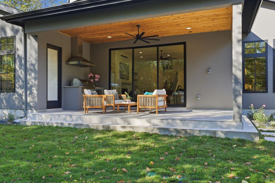 Back of property with ceiling fan, a patio area, and stucco siding