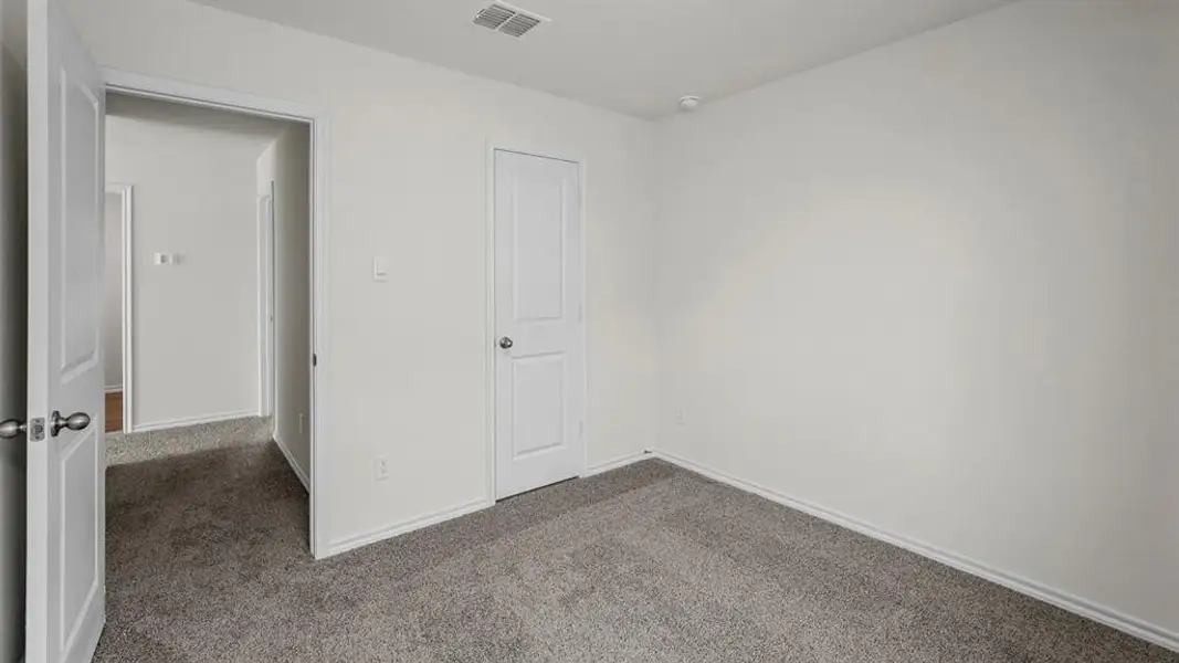This room features neutral-toned carpet, white walls, and white trim