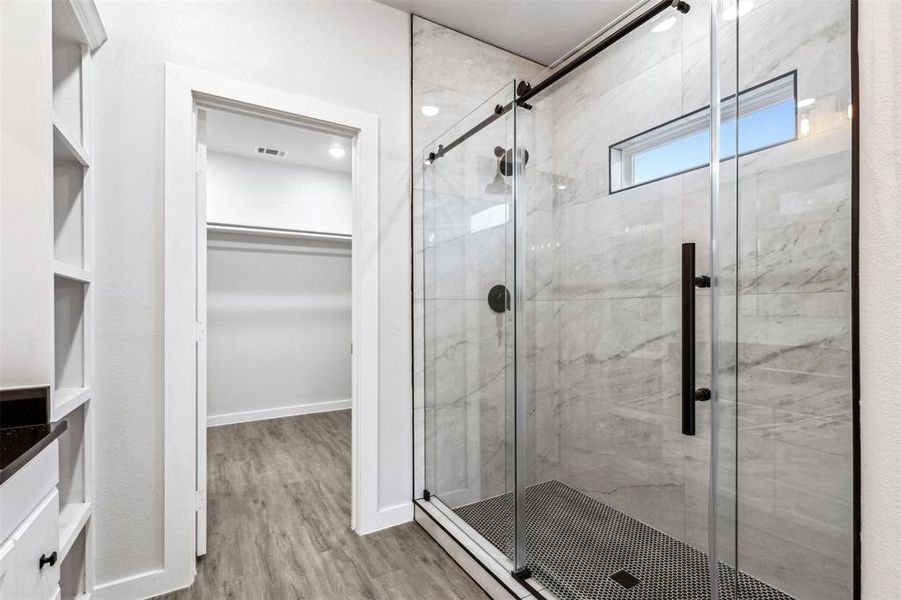 Primary Bathroom featuring hardwood / wood-style floors and a shower with shower door