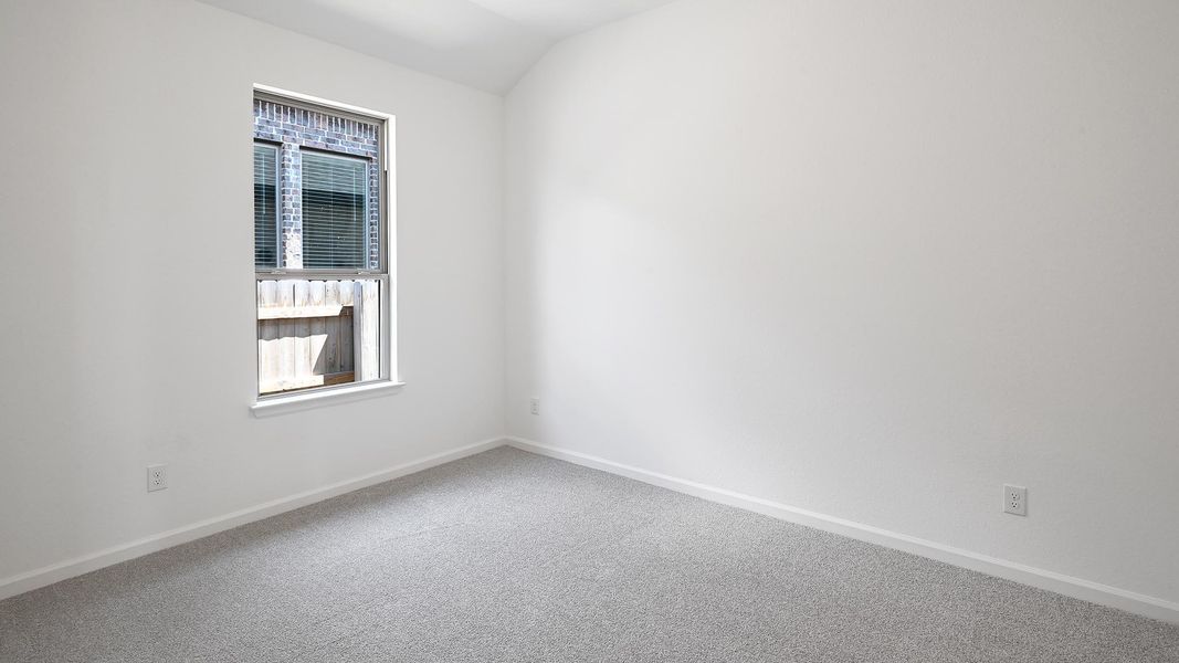 Unfurnished room featuring carpet floors and lofted ceiling Unfurnished room featuring carpet floors and lofted ceiling