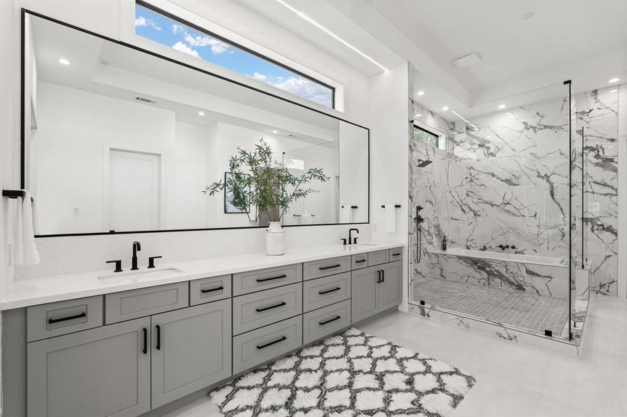 The Primary Bath Oasis features dual sinks with extended quartz countertops, elongated windows for privacy, tile floors and a glass encased walk-in shower.